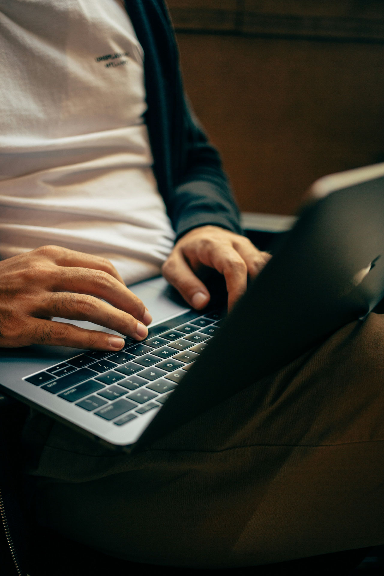 Collaborateur utilisant un ordinateur portable dans un environnement moderne, illustrant la transformation de la Digital Workplace avec Mozzaik365