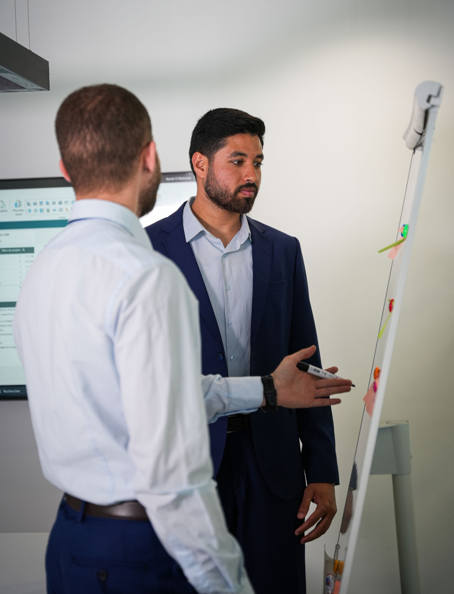 Professionnels devant un tableau en formation continue pour améliorer les performances de l’entreprise